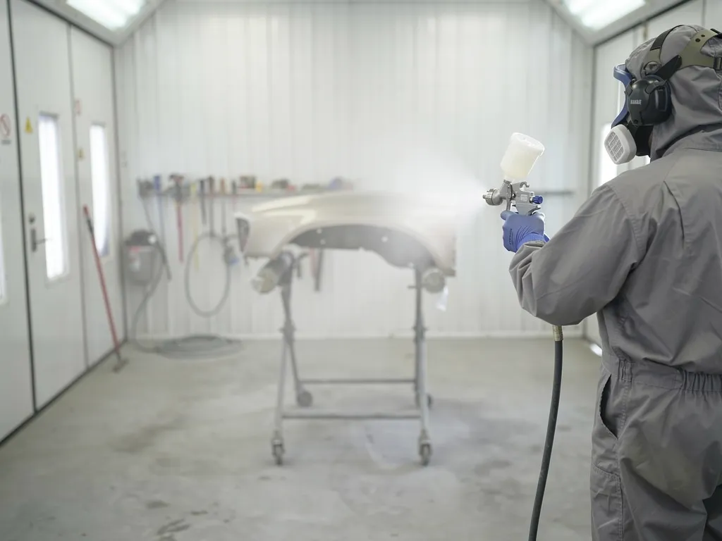 Benedict Auto Body technician painting a vehicle with precision color matching