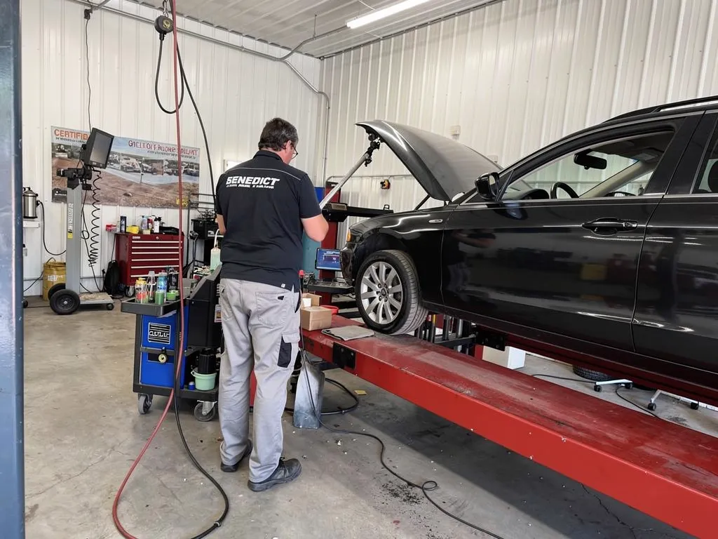 Benedict Auto Body technician performing frame straightening on a collision-damaged vehicle
